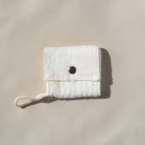 Funda de tela simple para jabón cerrada con un botón a presión metálico y una cuerda de algodón para colgar.