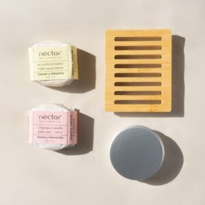 Pack delicado de Néctar V.A. Cosmética: Champú delicado/seco, acondicionador, jabonera de bambú y lata de aluminio. Los cosméticos vienen envueltos en papel encerado cerrado por una faja de papel.
