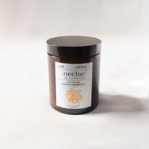 Vela n.01 de Néctar V.A. Cosmética, de cera de soja y olor cítrico a naranja y cardamomo. La vela viene en un vaso de vidrio opaco con la etiqueta de Néctar y una tapa a rosca. Vista frontal de la vela.