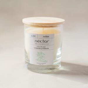 Vela n.04 de Néctar V.A Cosmética. Vela artesanal de cera de soja y olor sorpresa. La vela viene en un vaso de cristal transparente y una tapa de madera. Vista frontal de la vela.