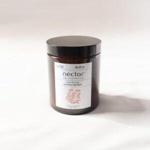 Vela n.02 de Néctar V.A Cosmética. De cera de soja y olor dulce a canela y sándalo. La vela viene en un vaso de vidrio opaco con la etiqueta de Néctar y una tapa a rosca. Vista frontal de la vela.